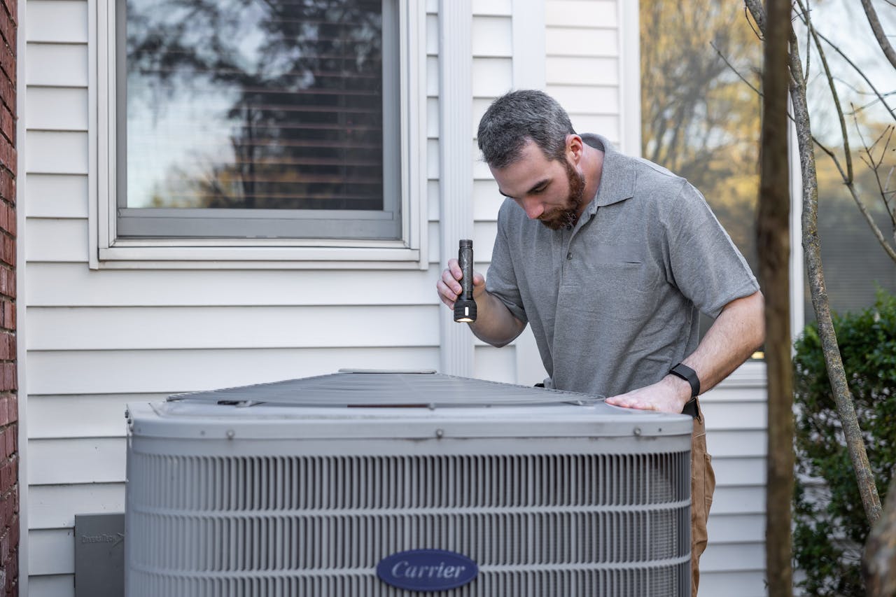 The Art of Drawing Readers In: Your attractive post title goes here A technician inspects an outdoor HVAC unit for maintenance.