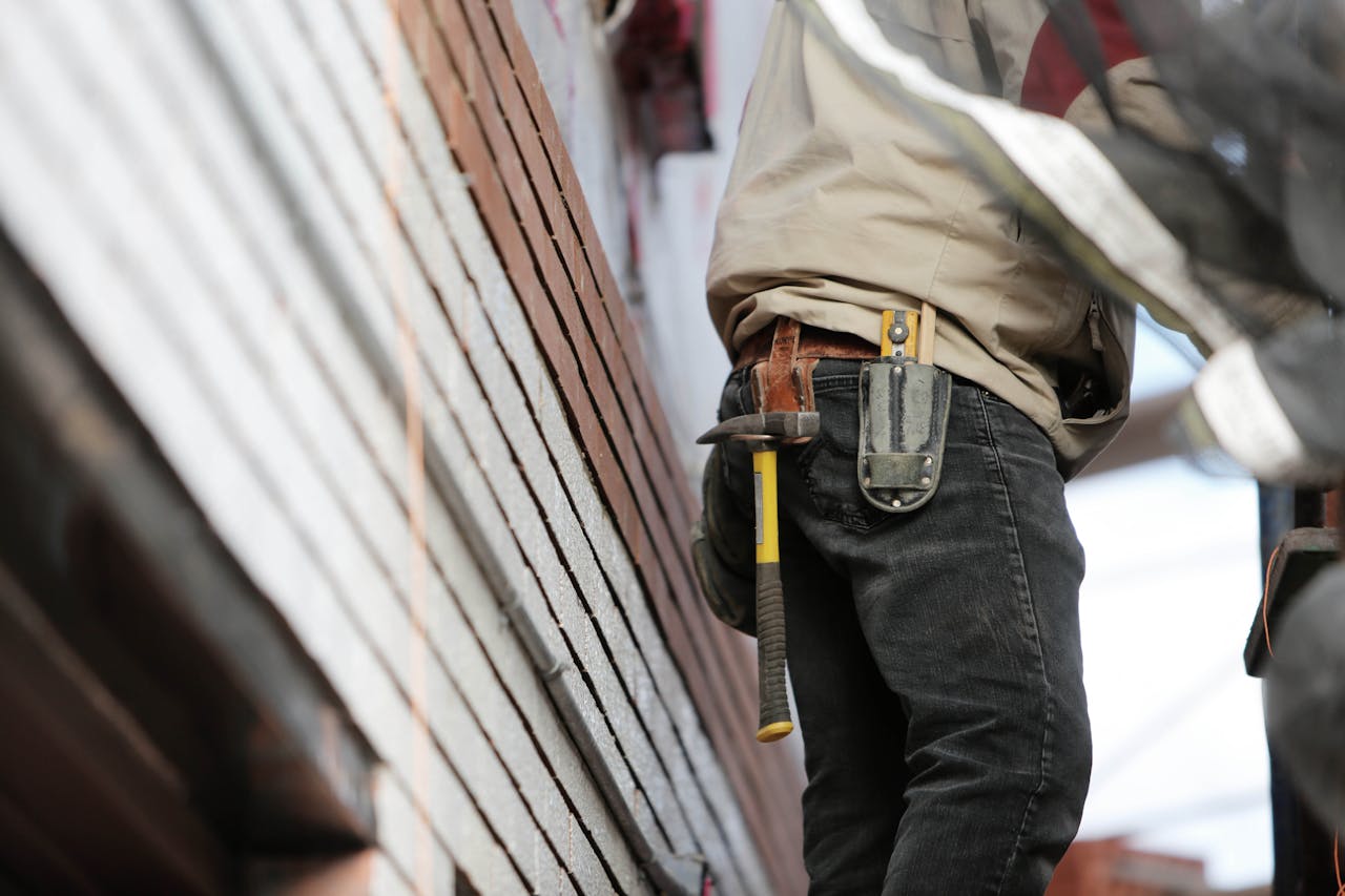 Mastering the First Impression: Your intriguing post title goes here Close-up of a construction worker with hammer and tools, focused on the job.